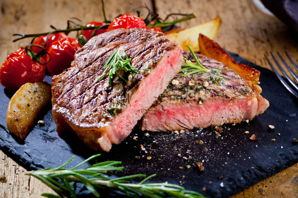 Szeletelve sült hús grill steak hátszín kést és a villát carving szett a fekete kő pala - Fotó, kép