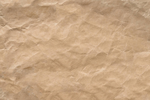 Bruin rimpel recycle papier achtergrond. Ambachtelijke papier textuur worden verfrommeld en gevouwen voor achtergrond. - Foto, afbeelding