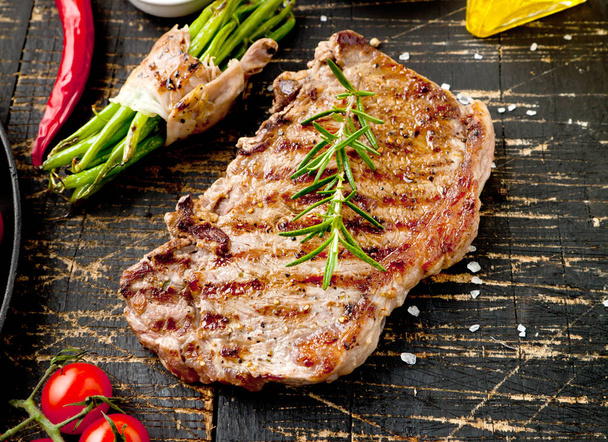 Čerstvé grilované maso. Grilovaný hovězí steak středně propečený na dřevěném prkénku. Pohled shora. - Fotografie, Obrázek