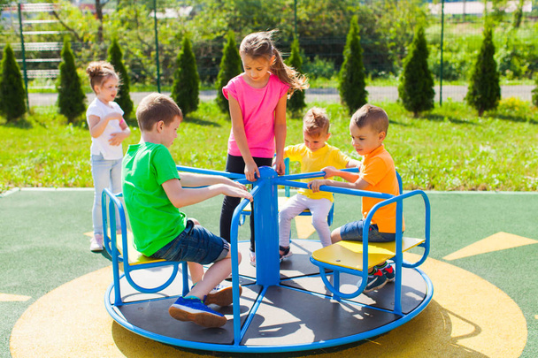 The kids spin the carousel in turn - Fotografie, Obrázek