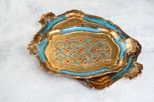 antike florentinische hölzerne türkisfarbene Tabletts auf Betongrund. Kopierraum für Text. - Foto, Bild