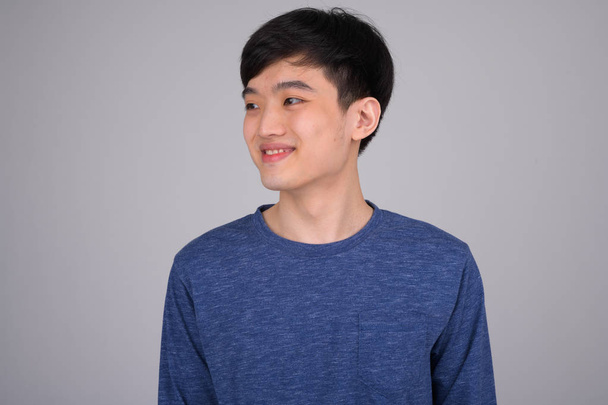 Face-boldog ázsiai fiatalember mosolygott, és a gondolkodás - Fotó, kép