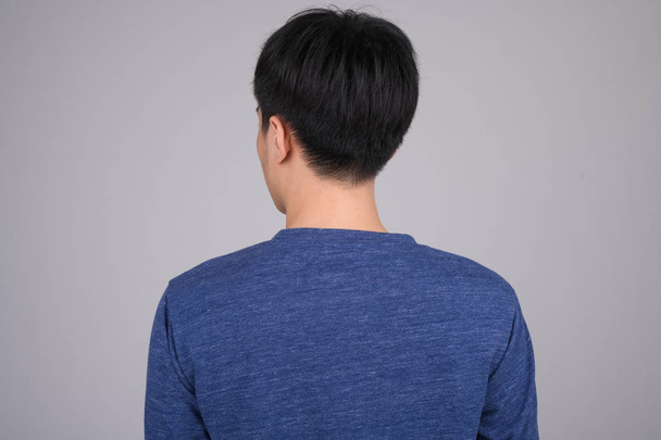 Vista trasera de la cabeza de un joven asiático sobre fondo blanco
 - Foto, imagen