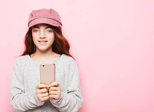 little girl kid with smartphone over pink background, close up - Foto, immagini