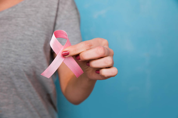 Frauenhand mit rosa Schleife Brustkrebs Bewusstsein. Konzept Gesundheitswesen und - Foto, Bild