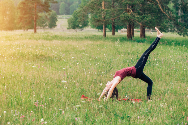Sports girl doing exercises in the woods, on the field, Park. Yoga, sports, health - Foto, immagini