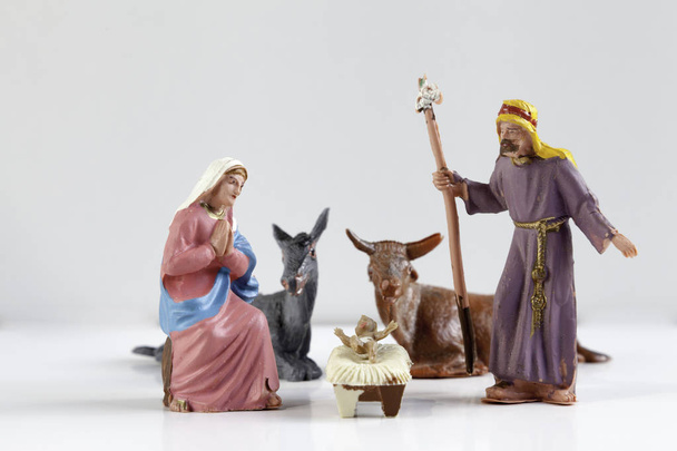 Christmas Manger scene with figures including Jesus, Mary, Joseph, cow and mule on white background - Zdjęcie, obraz