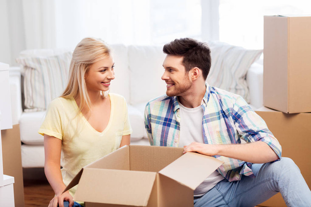 happy couple unpacking boxes at new home - Φωτογραφία, εικόνα