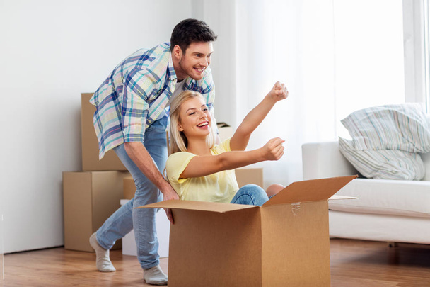 happy couple having fun with box at new home - Foto, Imagem