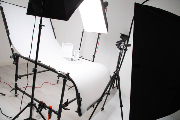 Beleuchtung im Studio für kommerzielle Arbeiten wie Fotoobjekt-Produkt mit großem Softbox-Snoot-Reflektorschirm und Stativen - Foto, Bild