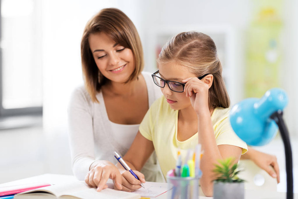 mother and daughter doing homework together - Фото, зображення