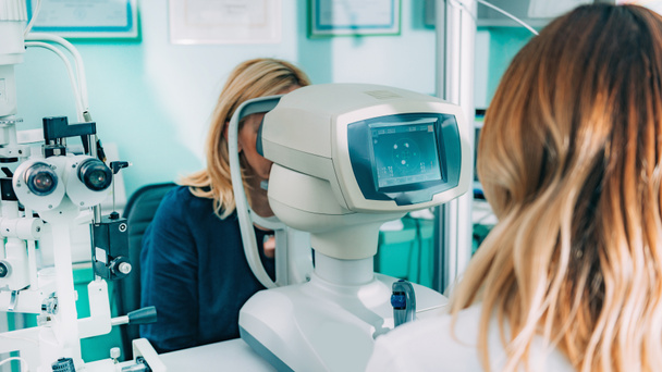Augenarzt untersucht Jungen mit Auto-Refraktometer - Foto, Bild