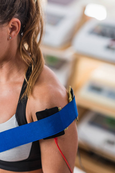 Electrical stimulation in physical therapy. Therapist positioning electrodes on a patient's shoulder - Φωτογραφία, εικόνα