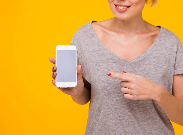 Ładna kobieta moda korzystanie smartphone w stylu rock czarny nad kolorowe pomarańczowe tło - Zdjęcie, obraz