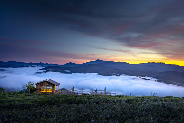 Petite jolie maison en bois sur le bord de la vallée avec plein de nuages au petit matin
 - Photo, image