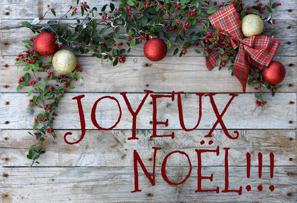 Christmas postcard frame on wooden background. For greeting card. Red and golden glitter balls, checked tie and green foliage with berries. "Merry Christmas"  - Photo, Image