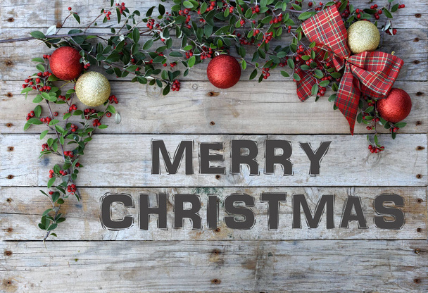 Рождественская открытка рамка на деревянном фоне. Для поздравительной открытки. Красные и золотые блестящие шарики, проверенный галстук и зеленая листва с ягодами. "Веселого Рождества
"  - Фото, изображение