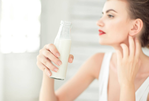 Young woman holding bottle of soy milk - Foto, Imagen