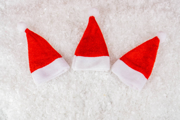 Три шляпы Санта-Клауса в полукруге на снегу, скопировать пространство
 - Фото, изображение