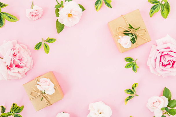 Marco con rosas y caja de regalo sobre fondo rosa pastel. Asiento plano, vista superior. Día de San Valentín
 - Foto, imagen