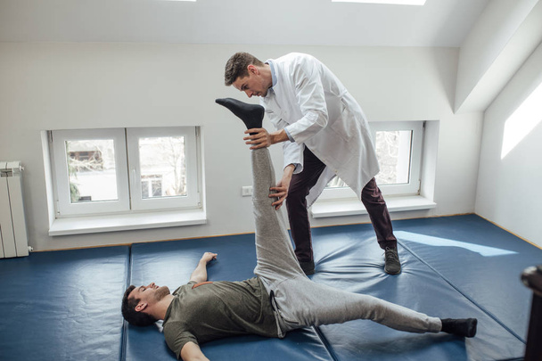 Doctor Helping Patient Stretch  - 写真・画像