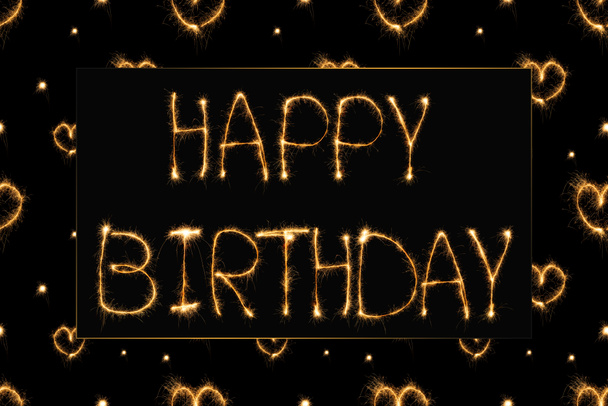 close up view of happy birthday light lettering and hearts on black backdrop - Фото, изображение