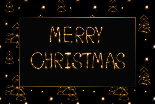 close up view of merry christmas light lettering and fir tree light signs on black background - Foto, Bild