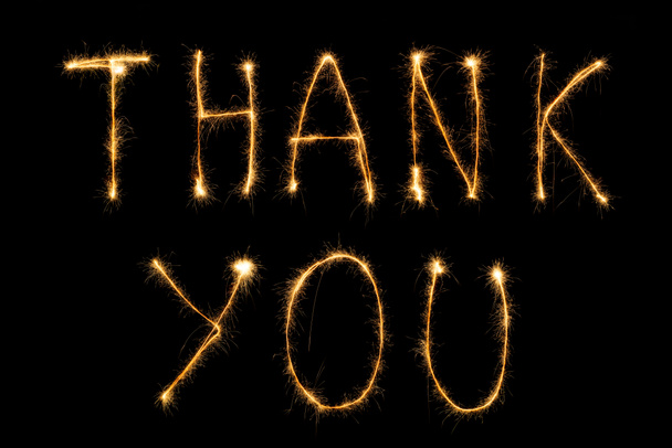 close up view of thank you light lettering on black backdrop - Foto, Imagen