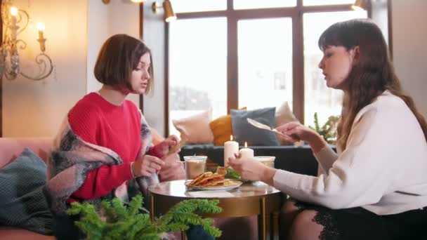 Duas jovens sentadas no café e conversando enquanto comem panquecas. Grande interior
 - Filmagem, Vídeo