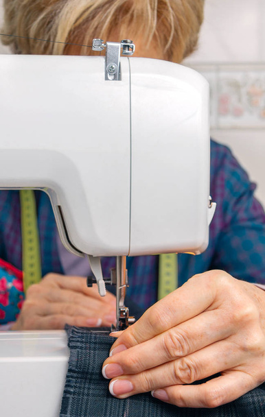 Senion costurera mujer que trabaja en la máquina de coser
 - Foto, imagen