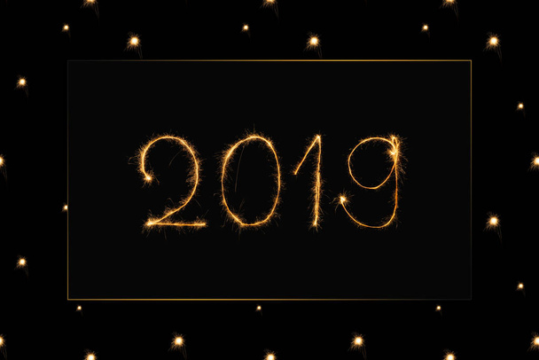 close up view of 2019 light sign on black background - Foto, afbeelding