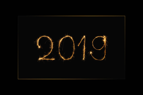 close up view of 2019 year light sign on black background - Foto, afbeelding