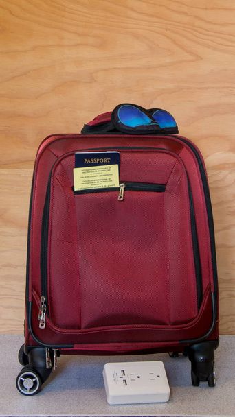  Czerwoną walizkę z paszportu i żółtą kartę Wyświetlono plus oko maski i adapter/power surge - gotowy do podróży - Zdjęcie, obraz