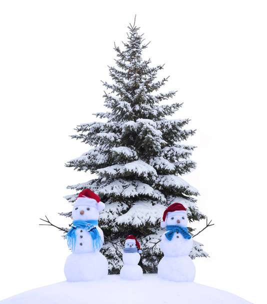 Árvore de Natal na neve isolada no fundo branco com bonecos de neve
. - Foto, Imagem