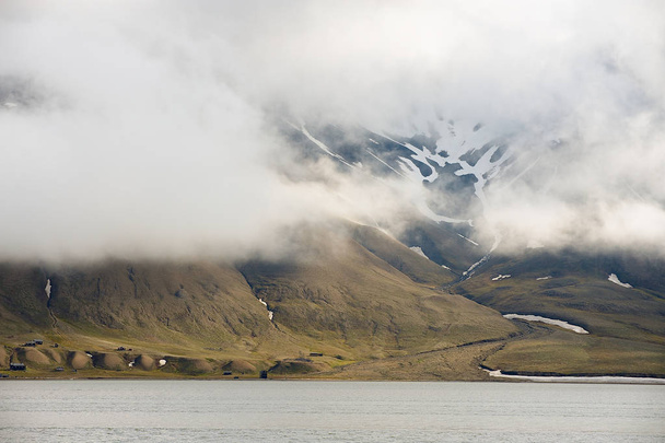 Heavy clouds over the arctic shore of the polar archipelago of Spitsbergen near Longyearbyen, Norway. - Photo, image