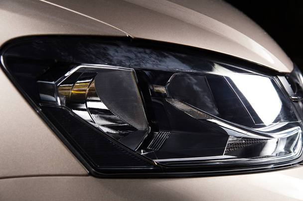 Auto nieuwe koplamp close-up. Gepolijste auto hoofdlamp. Studio shoot. - Foto, afbeelding