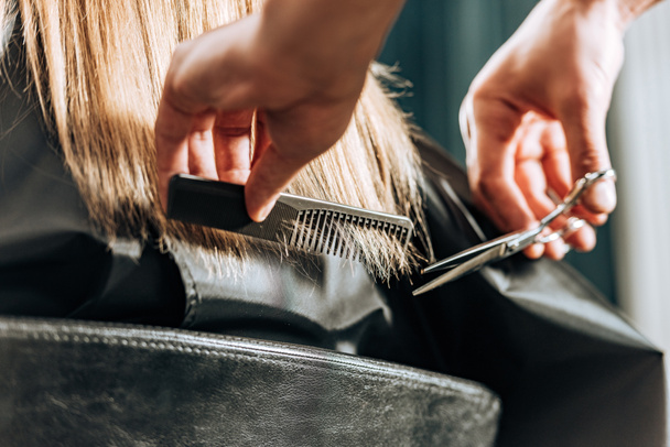 gros plan vue partielle de coiffeur couper les cheveux à belle jeune femme dans le salon de beauté
  - Photo, image