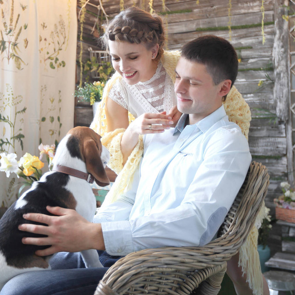 young couple with pet sitting on a chair - Foto, Bild