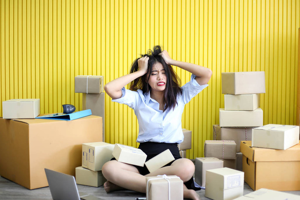 Tired unhappy of   Young asian girl is freelancer Start up small business owner writing address on cardboard box at workplace,Shipping shopping online small business entrepreneur SME or freelance - Fotoğraf, Görsel