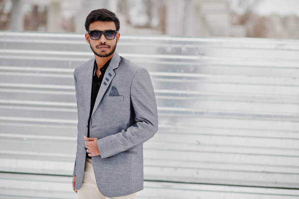 Casual young indian man in silver jacket and sunglasses posed against steel background. - Fotografie, Obrázek