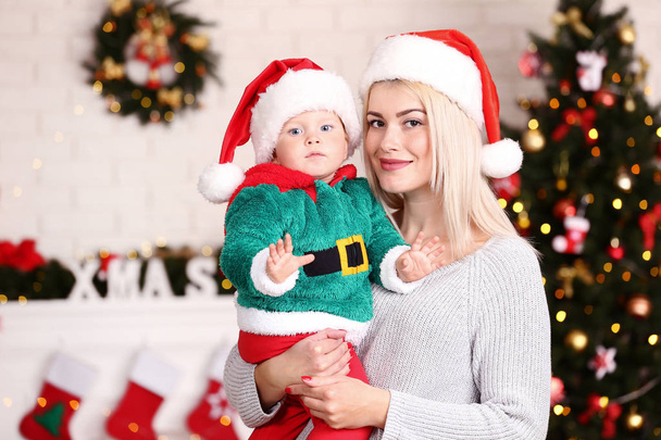 Madre e figlio in cappelli di Babbo Natale celebrano il Natale a casa
 - Foto, immagini