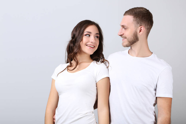 Happy young couple on grey background - Foto, Imagen