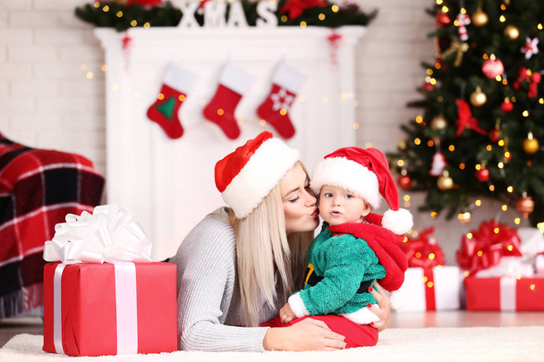 Matka i syn w santa kapelusze świętować Boże Narodzenie w domu - Zdjęcie, obraz