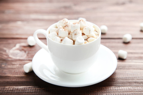 Cappuccino with marshmallows in cup on brown wooden table - Foto, Imagen