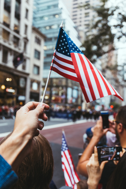 visão parcial do homem segurando bandeira americana durante desfile na rua em Nova York, EUA
 - Foto, Imagem