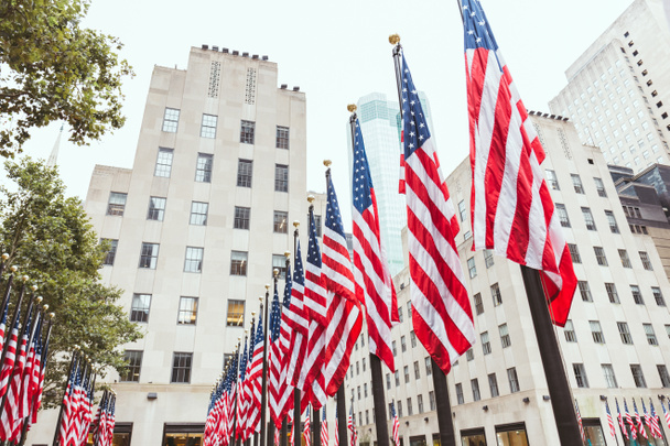 low angle view of american flags and buildings, new york, usa - Photo, Image