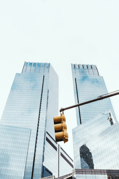 nízký úhel pohledu mrakodrapů, semafor a jasné oblohy v new york city, usa - Fotografie, Obrázek