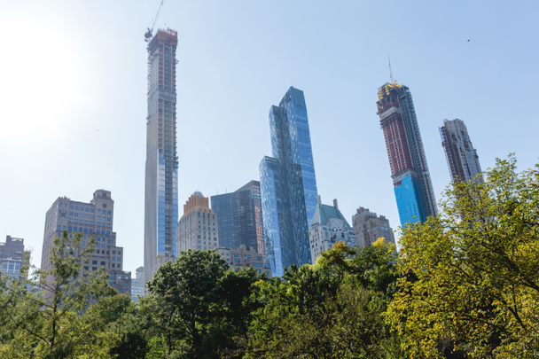 міська сцена з деревами в міському парку і хмарочосах в Нью-Йорку, США
 - Фото, зображення