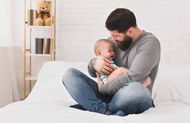 Giovane padre che tiene piangendo sonnolento carino neonato
 - Foto, immagini
