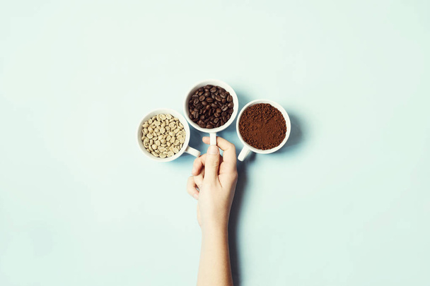 Different types of coffee - ground, grain and unroasted on blue pastel background - Foto, Imagen